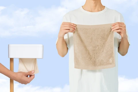 Person holding a soft towel next to a toilet fitted with Flushy