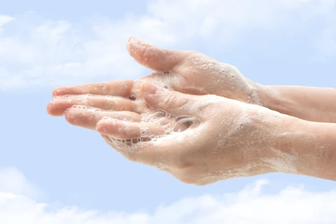 Soapy hands being washed under running water
