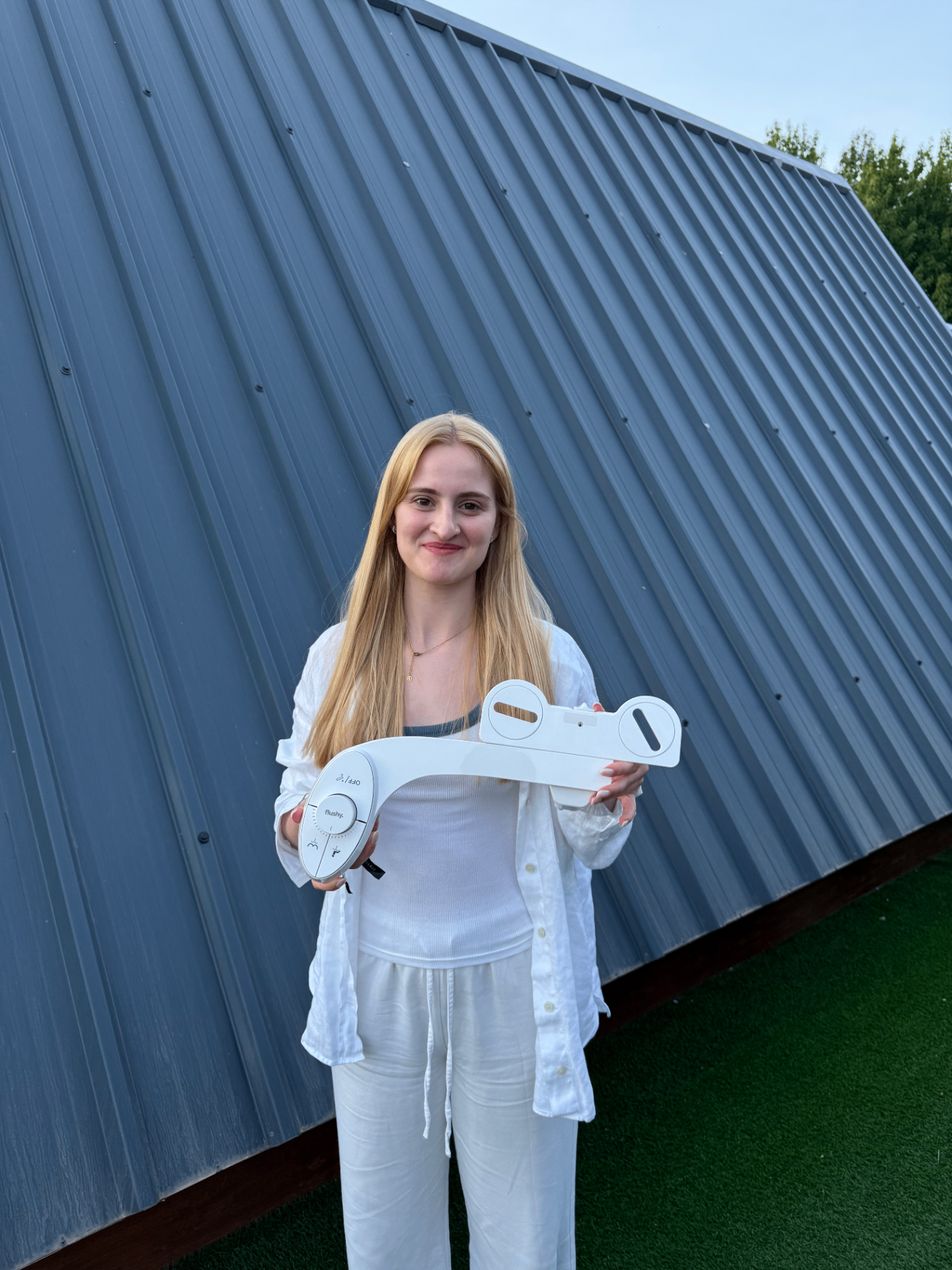 Woman holding a Flushy bidet outdoors